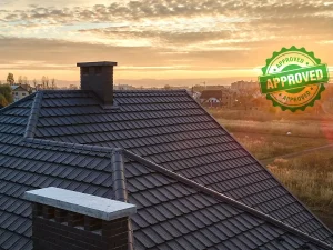 A rooftop view at sunset, featuring a chimney and a landscape of houses, with an "Approved" seal prominently overlaying the image.