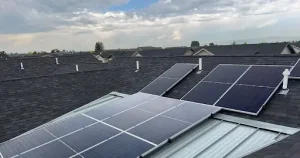 Solar panels installed on a residential roof under a cloudy sky.