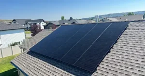 Solar panels on the roof of a suburban house with neighboring homes in the background. 