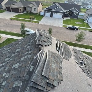 Bismarck Shingle Roofing by Wegner Roofing & Solar featuring piles of removed asphalt shingles on a roof underlayer.