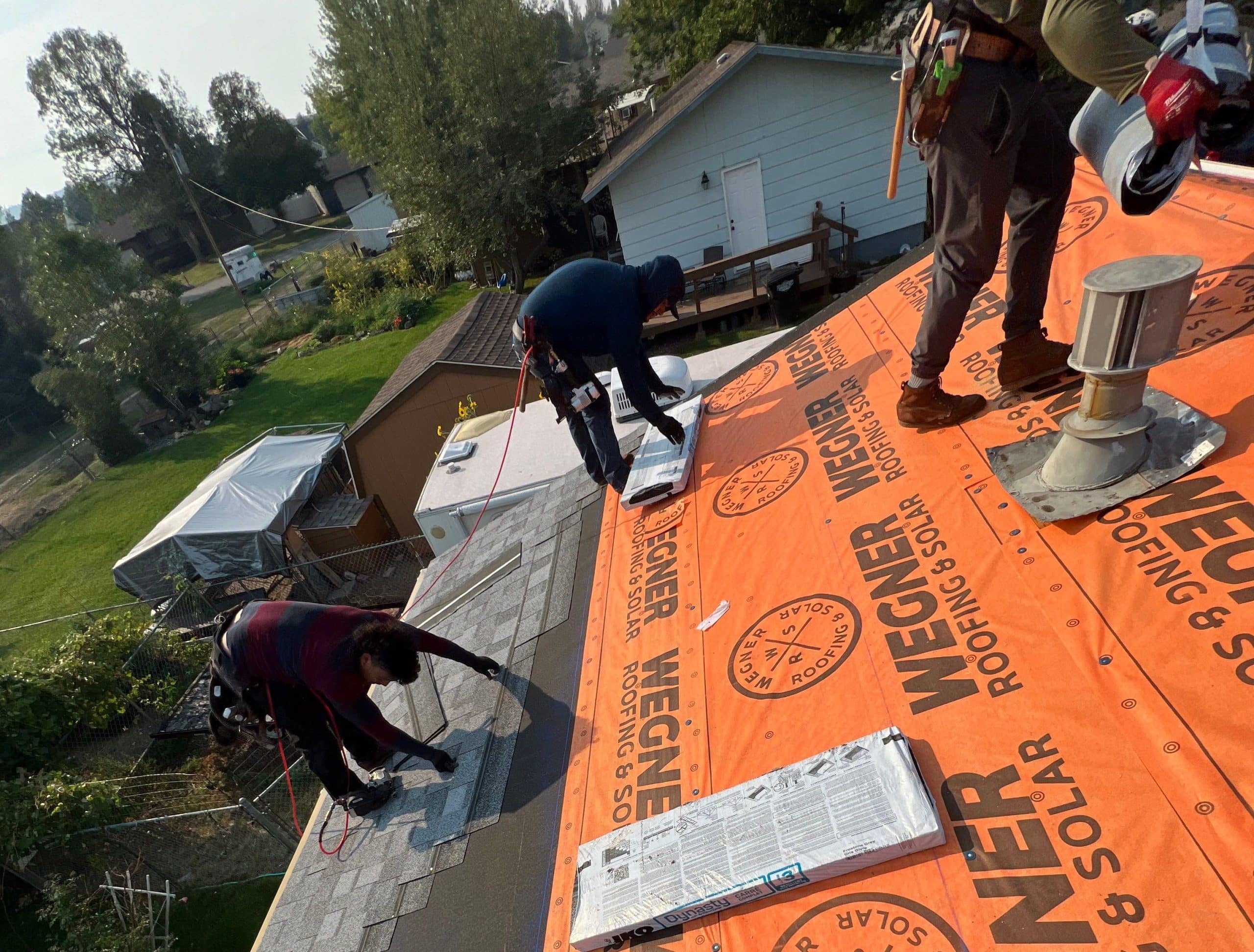 Contractors from Wegner Roofing & Solar, one of the top Spearfish Roofing Companies, install new shingles on a roof.